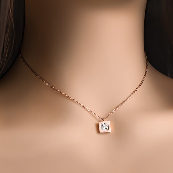 Woman wearing a rose gold square love crystal necklace