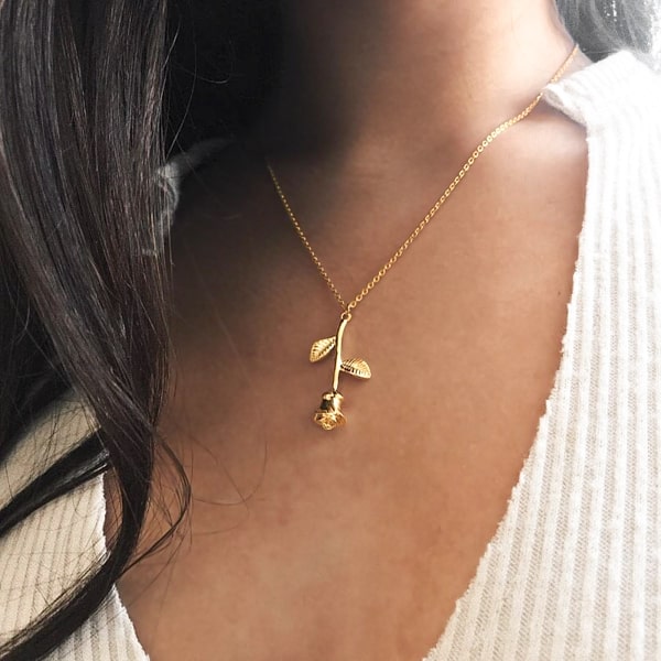 Woman wearing a gold rose pendant necklace