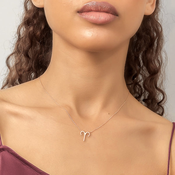 Woman wearing a rose gold Aries necklace