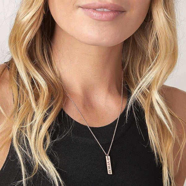 Woman wearing a rose gold Roman bar of wisdom necklace