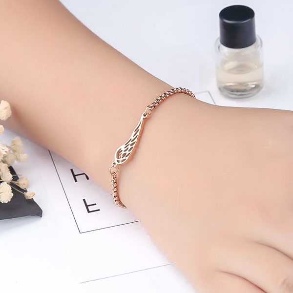 Rose gold angel wing bracelet on a woman's wrist