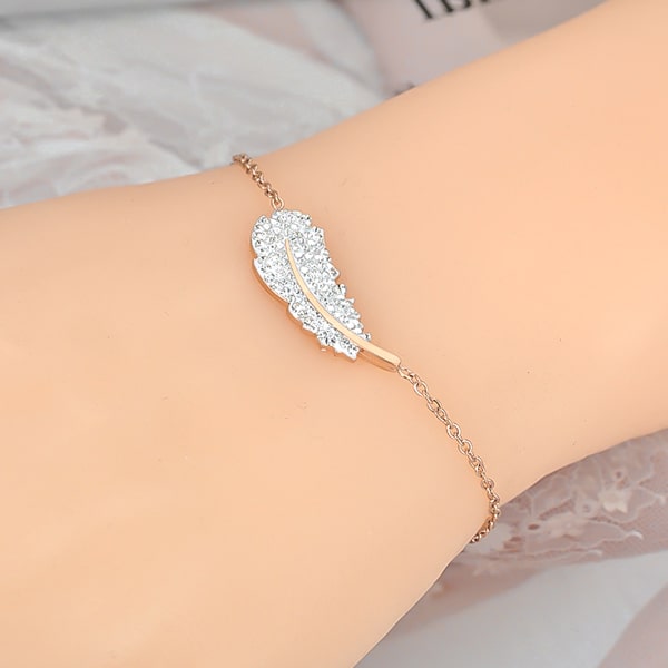 Rose gold crystal feather bracelet displayed on a woman's wrist