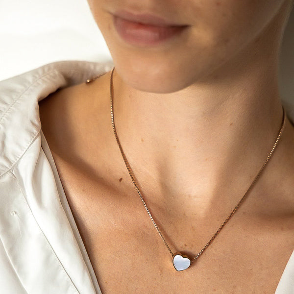 Woman wearing a rose gold double-sided heart necklace