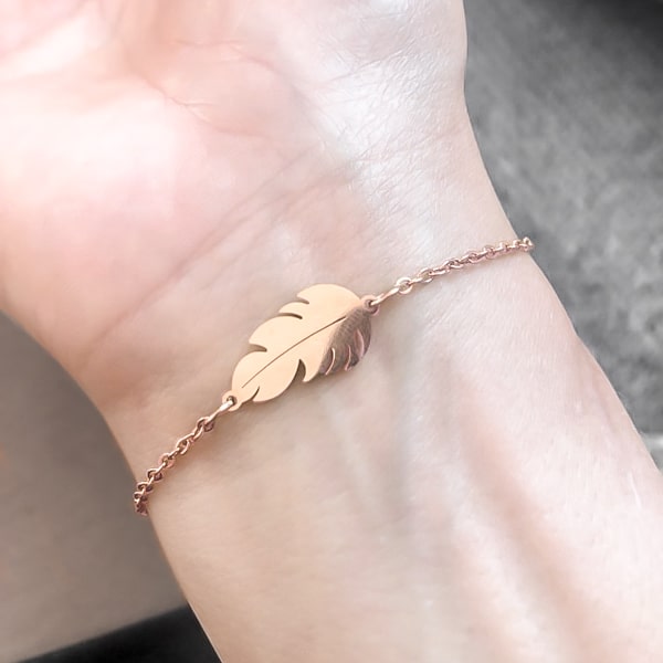 Rose gold feather bracelet on a woman's wrist