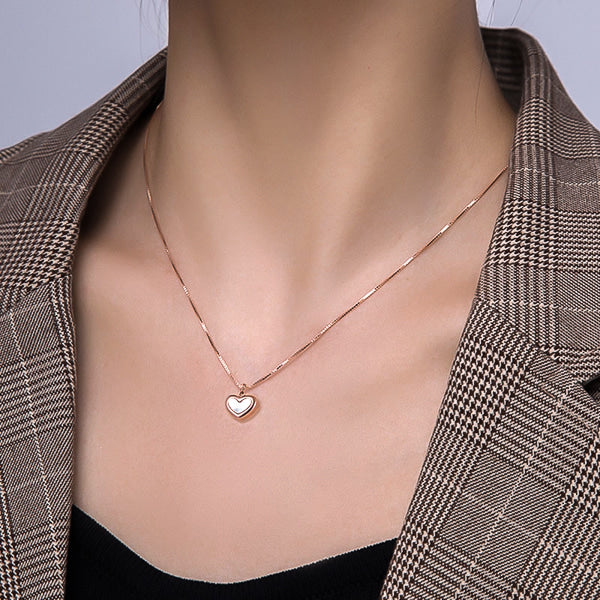 Woman wearing a rose gold shell heart pendant necklace