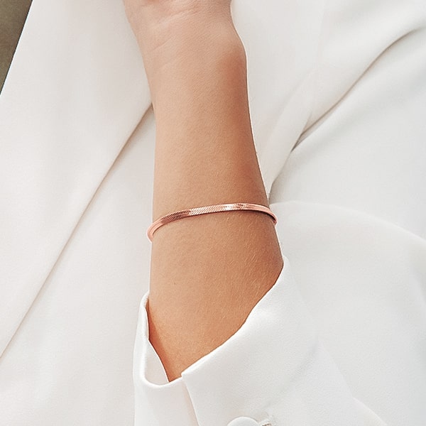 Rose gold snake chain bracelet on a woman's wrist