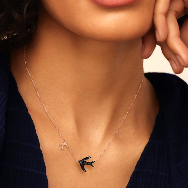 Woman wearing a rose gold swallow necklace