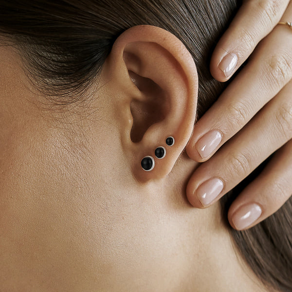 Woman wearing black agate stud earrings