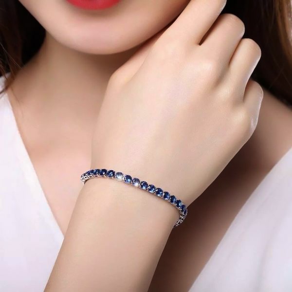Sapphire blue cubic zirconia tennis bracelet on a woman's wrist