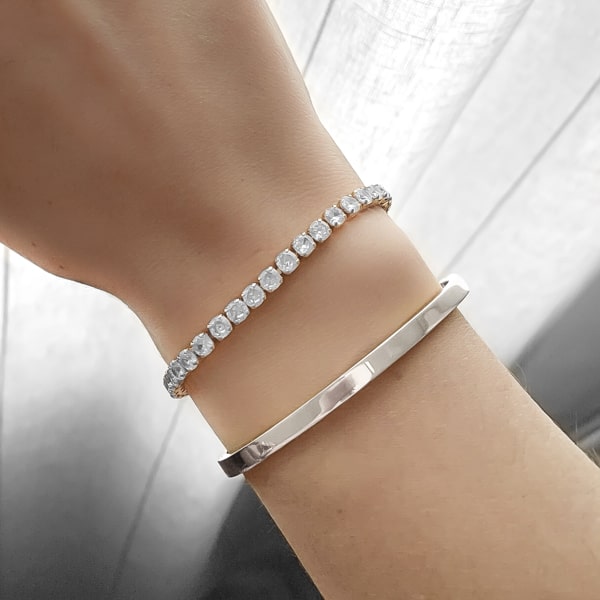 Woman wearing a 4mm silver bangle bracelet on her wrist