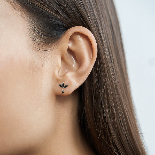 Woman wearing silver and black lotus earrings