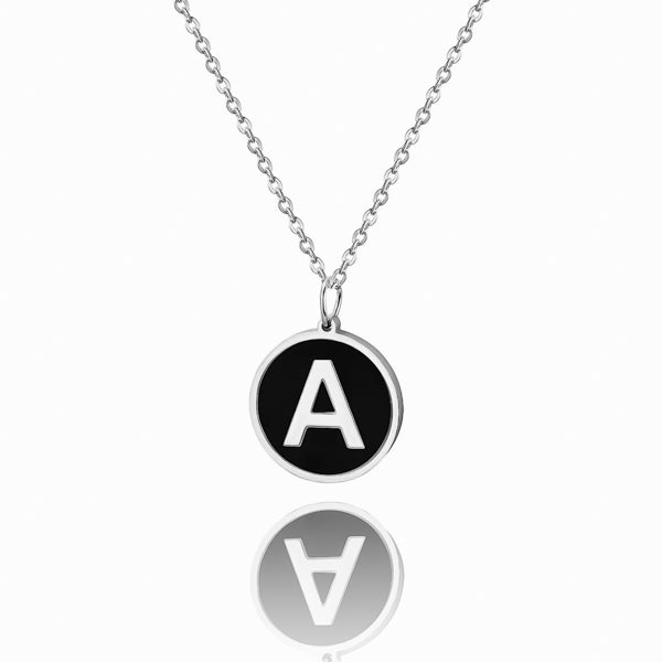 Silver and black round letter coin pendant necklace closeup