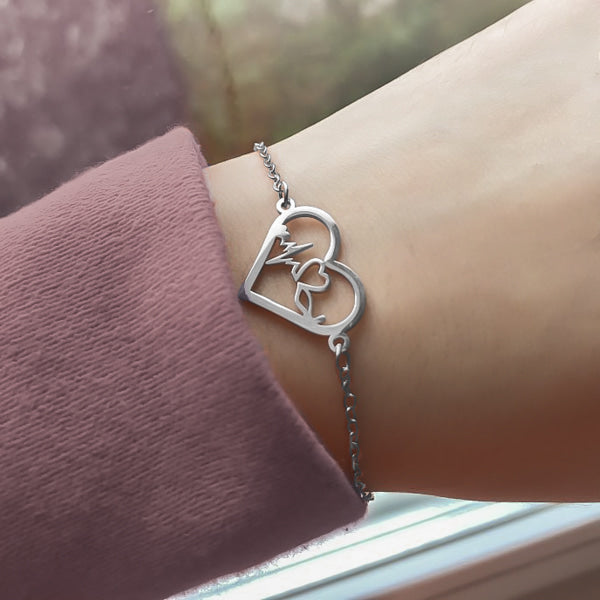 Woman wearing a silver heartbeat bracelet on her wrist