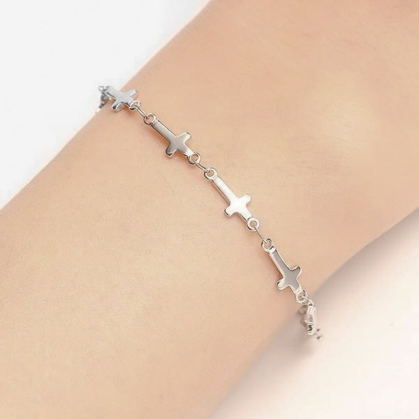 Woman wearing a silver cross chain bracelet