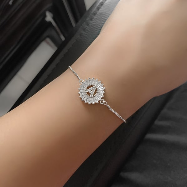 Woman wearing a silver crystal initial bracelet
