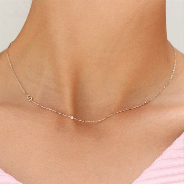 Woman wearing a silver asymmetrical initial letter chain necklace
