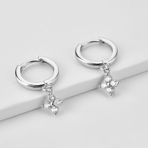 Silver huggie hoop earrings with a dangling cubic zirconia flower