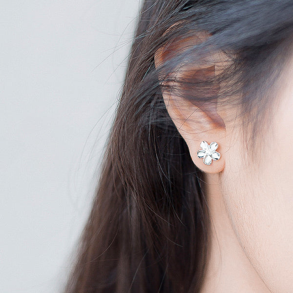 Woman wearing silver flower earrings