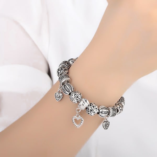 Woman wearing a silver vintage heart charm bracelet