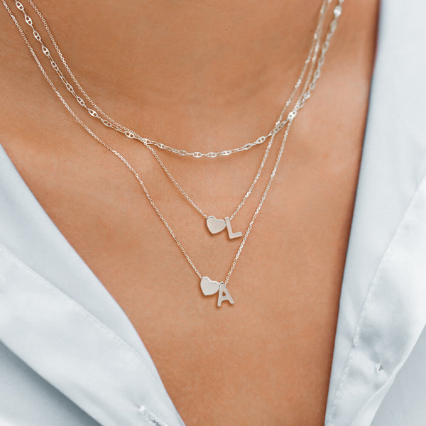 Woman wearing a silver heart initial letter necklace