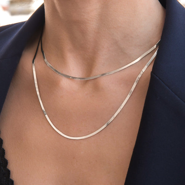 Woman wearing a 2mm silver herringbone chain necklace