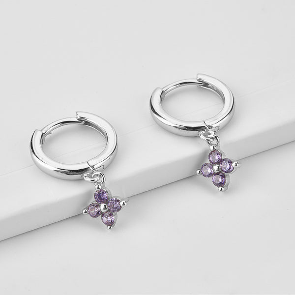 Silver huggie hoop earrings with a dangling purple cubic zirconia flower