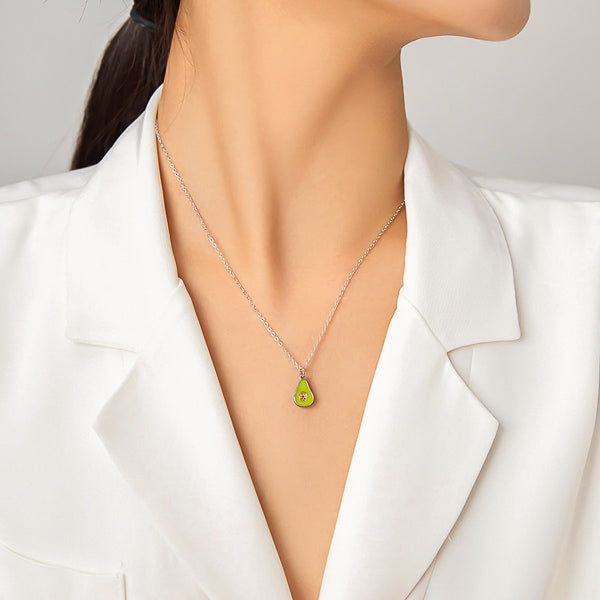 Green avocado fruit pendant on a silver necklace on woman's neck