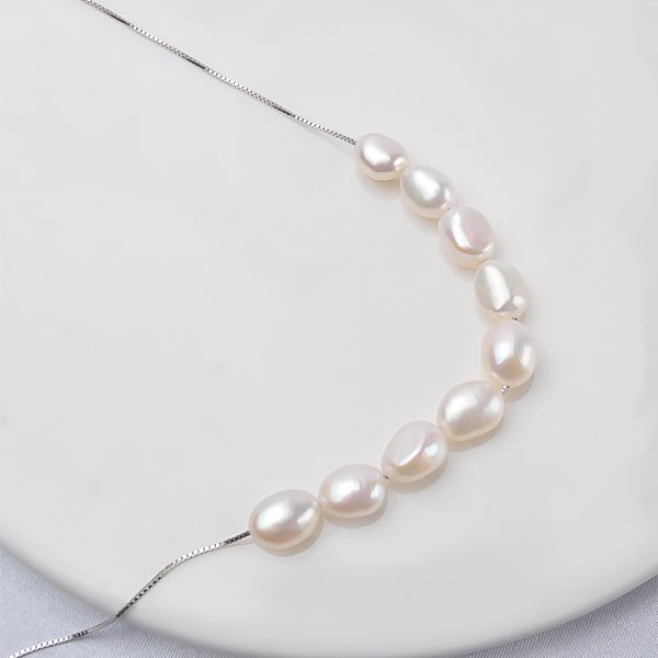 6-7mm white baroque freshwater pearls on a silver necklace close up