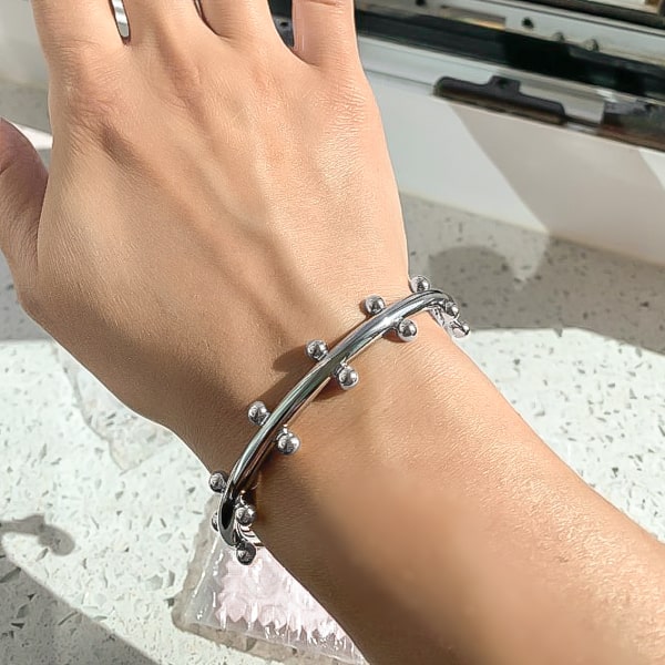 Silver beaded cuff bracelet displayed on a woman's wrist