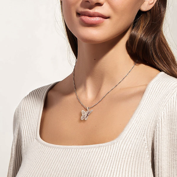 Woman wearing a silver butterfly necklace on a Singapore chain