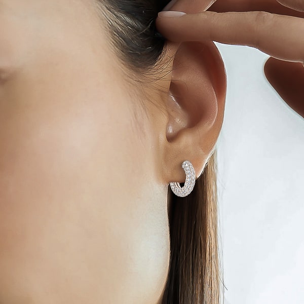 Woman wearing silver chunky huggie hoop earrings