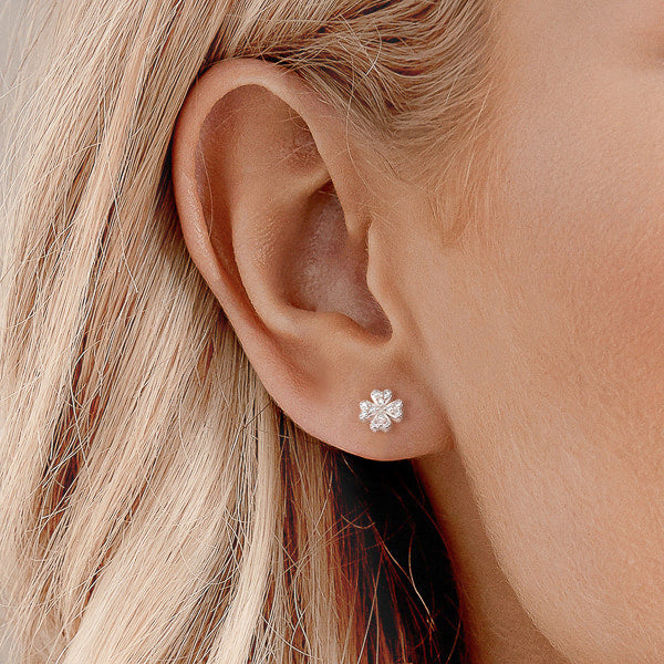 Silver crystal clover stud earrings on model
