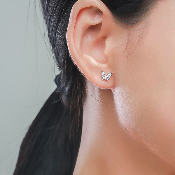 Woman wearing silver crystal butterfly stud earrings