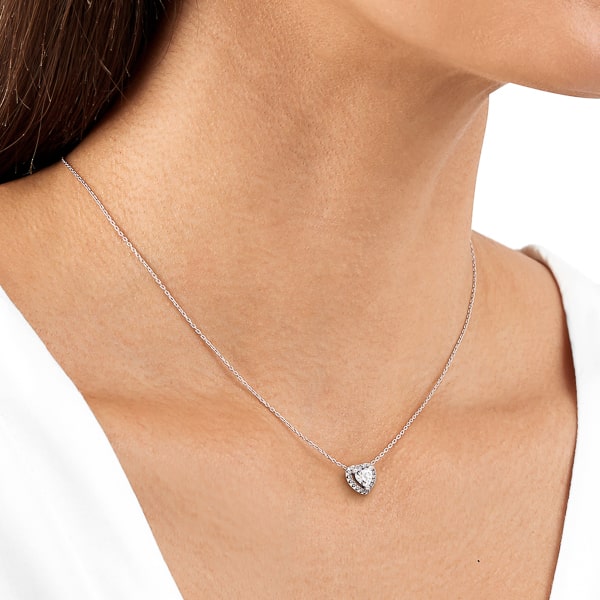 Woman wearing a crystal halo heart on a silver necklace