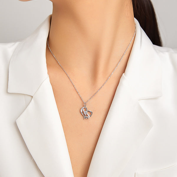 Woman wearing a silver heart & crystal infinity pendant necklace