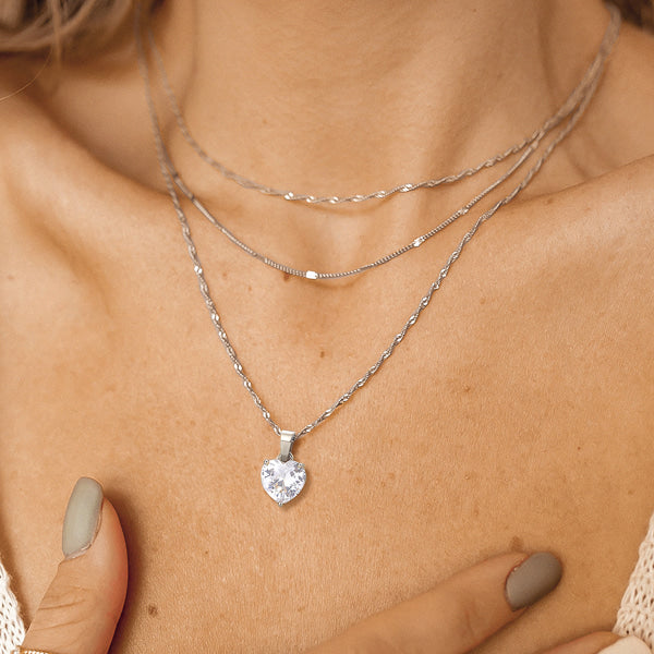Woman wearing a silver crystal heart pendant necklace