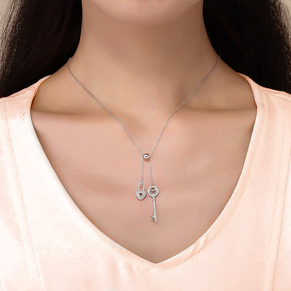 Woman wearing a silver key and lock heart necklace with crystal trim