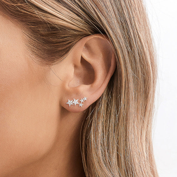 Silver crystal star cluster earrings on woman