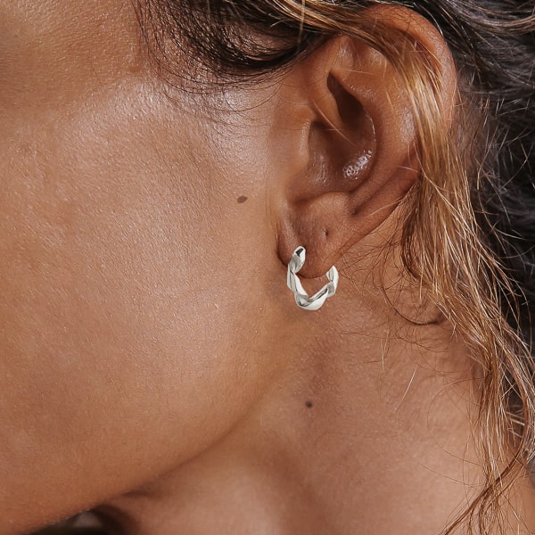 Woman wearing silver curly hoop earrings