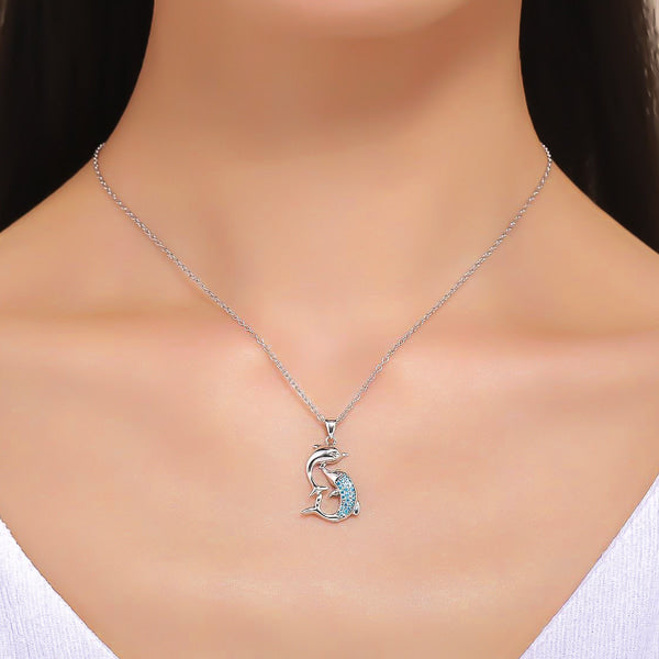 Woman wearing a dolphin pendant on a silver necklace