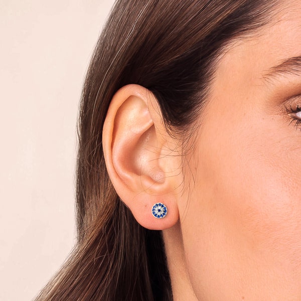 Woman wearing silver evil eye stud earrings