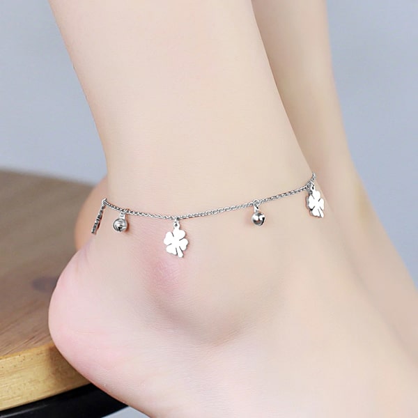 Silver four-leaf clover anklet on a womans ankle
