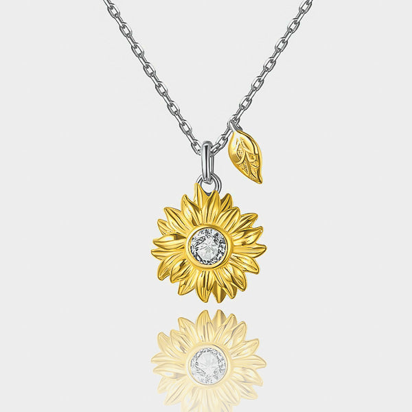 Gold sunflower and leaf pendant on a silver necklace details