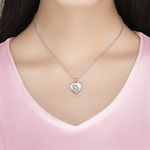 Woman wearing a silver heart and cats pendant necklace