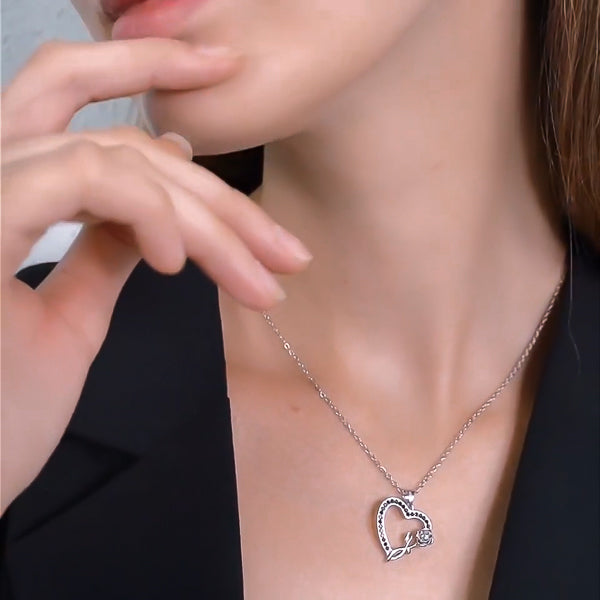 Woman wearing a silver heart flower pendant necklace