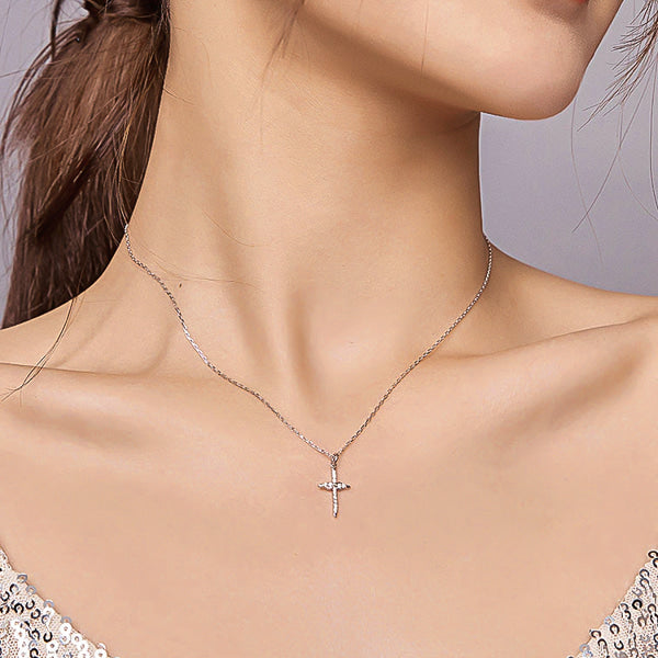 Woman wearing a silver infinity crystal cross pendant necklace