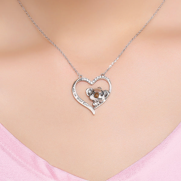 Woman wearing a silver koala and heart necklace