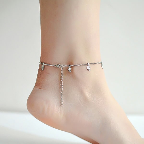 Silver leaf lucky charm anklet on a woman's ankle