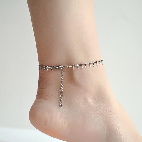 Silver lucky charm anklet on a woman's ankle