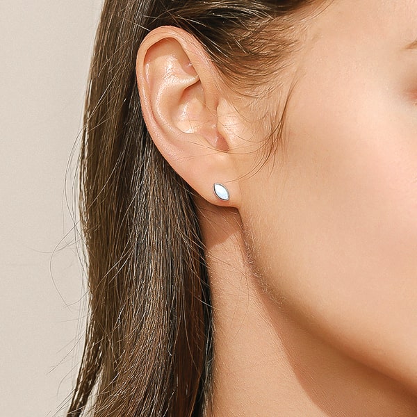 Woman wearing silver mini marquise opal stud earrings